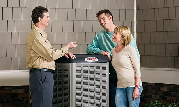 man and woman standing beside HVAC unit talking to technician