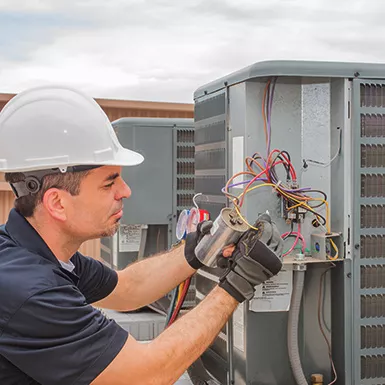An HVAC technician running maintenance diagnostics on an air conditioner