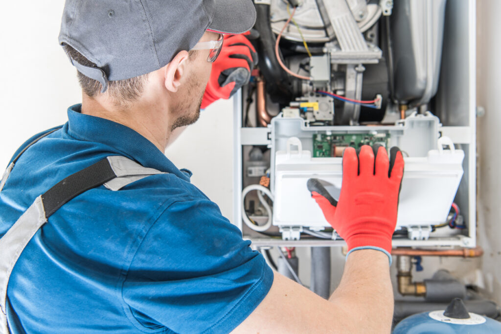 Heating technician checking a furnace for issues