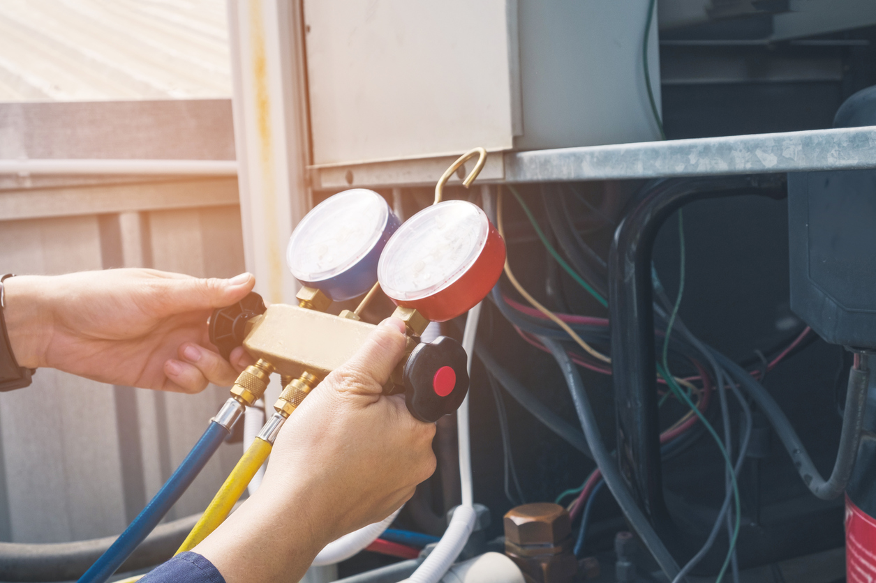 Technician using HVAC gauge during service