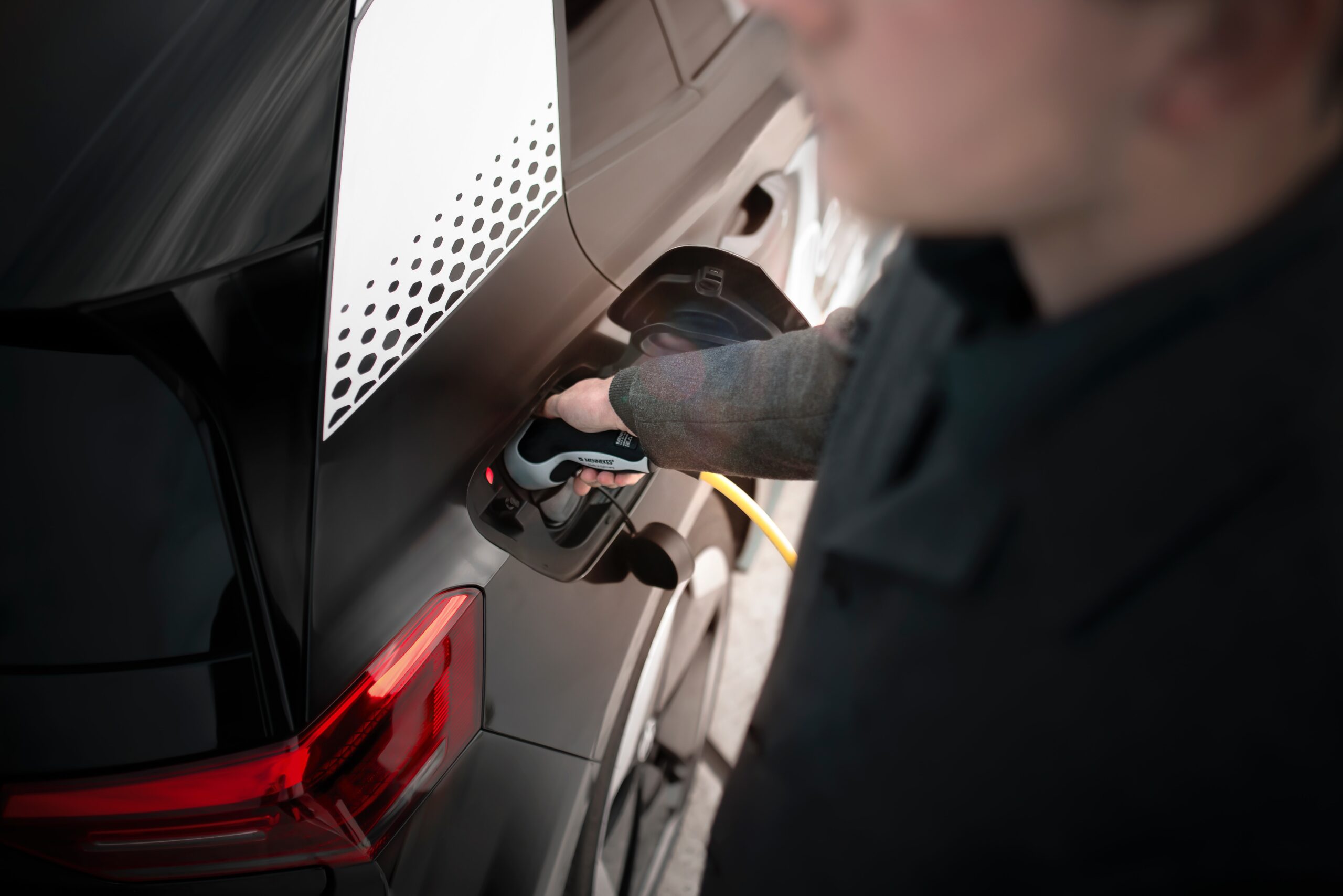 Man charging his electric vehicle at his home’s EV charging station
