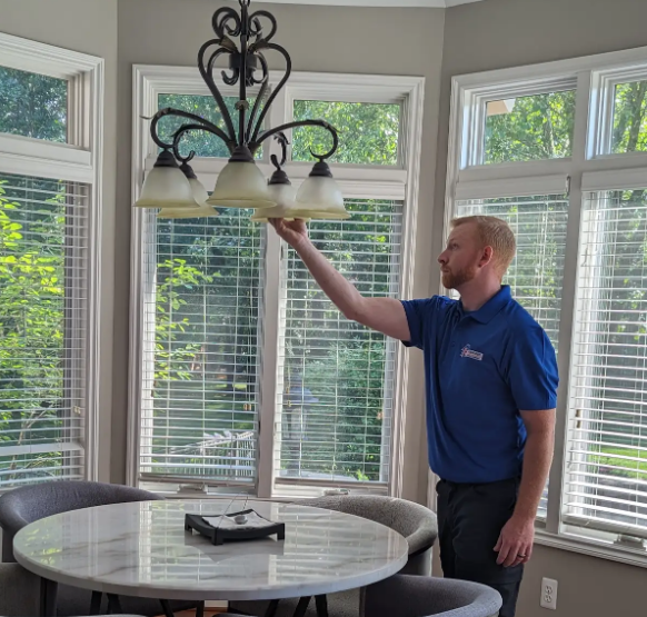 Electrician inspecting residential kitchen light fixture