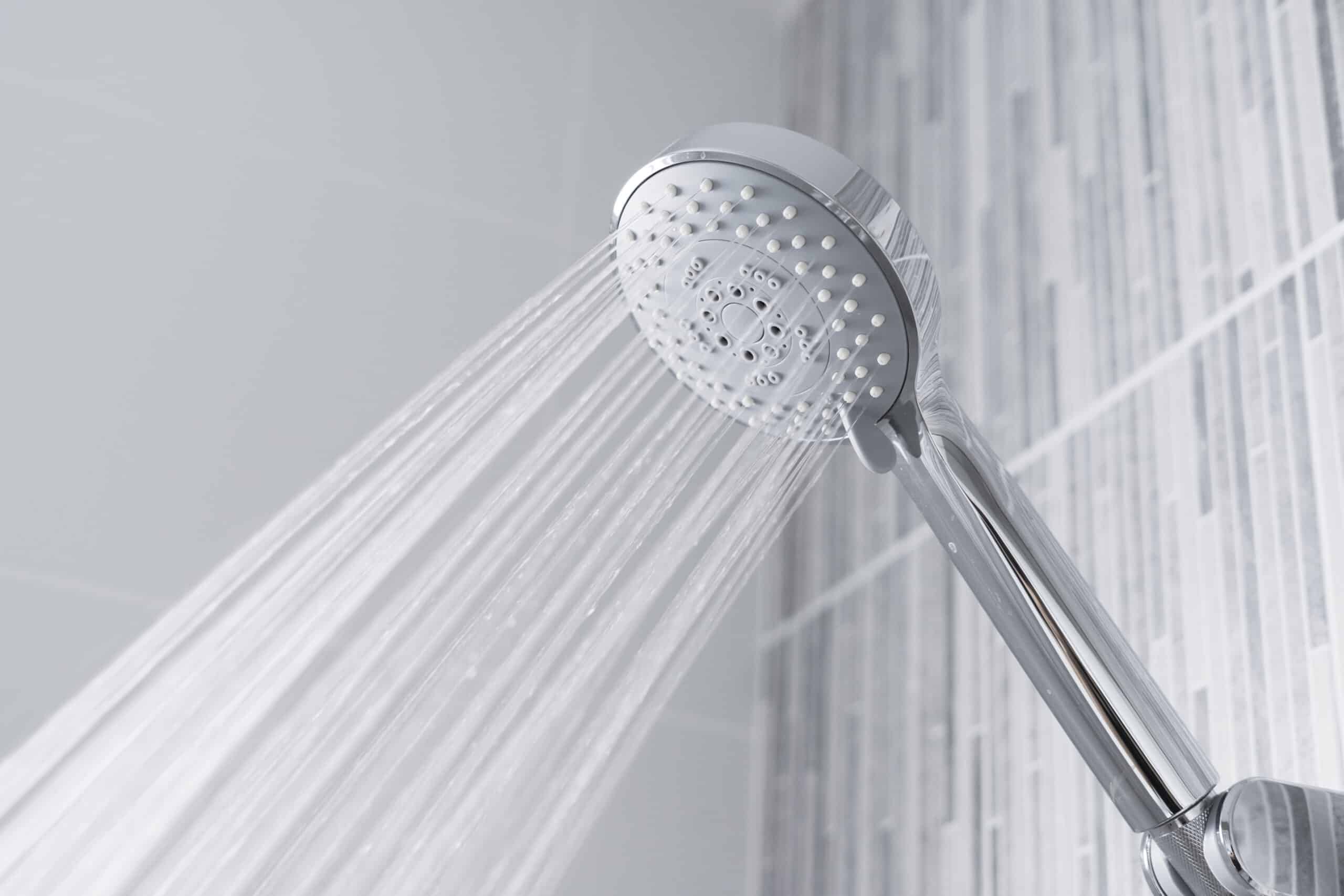 Closeup of shower head running hot water